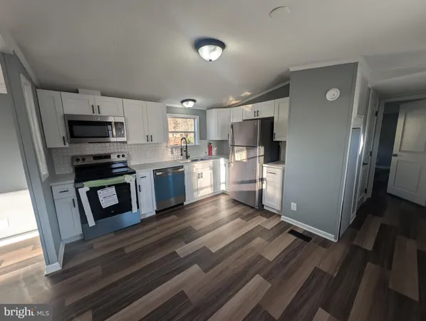 a kitchen with stainless steel appliances a refrigerator and a stove top oven