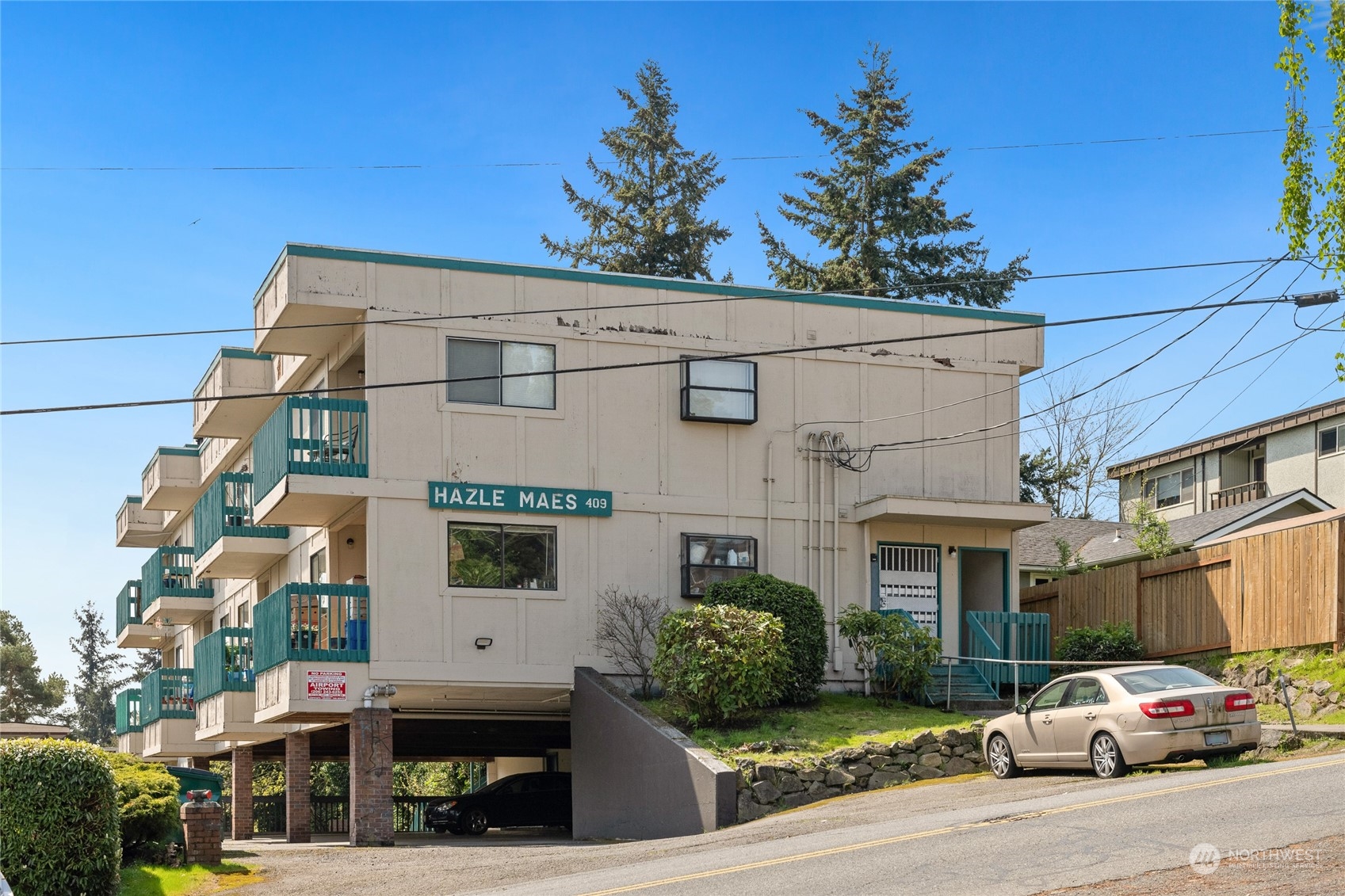 409 Southwest 155th Street Burien, WA 98166 - Photo 4 of 22 a front view of a building with lot of cars and trees