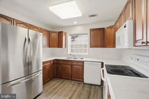 a kitchen with stainless steel appliances a sink a stove a refrigerator and cabinets