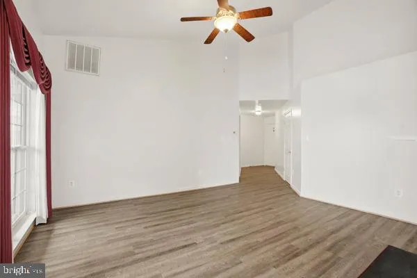a view of empty room with wooden floor
