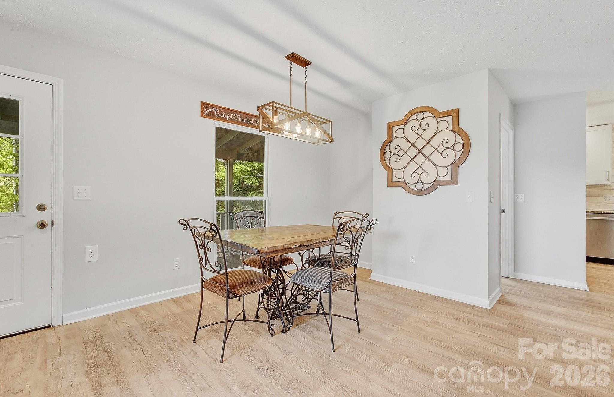 2131 Coleman Mountain Road Waynesville, NC 28785 - Photo 11 of 40 a view of a dining room with furniture window and wooden floor