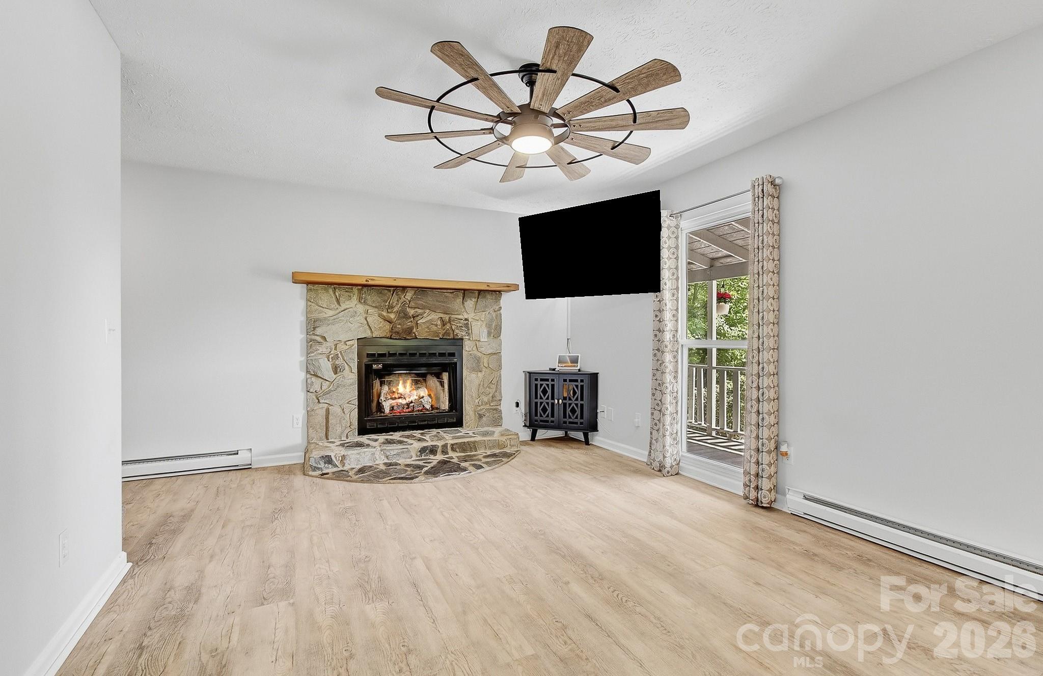 2131 Coleman Mountain Road Waynesville, NC 28785 - Photo 13 of 40 a view of an empty room with a fireplace and a window