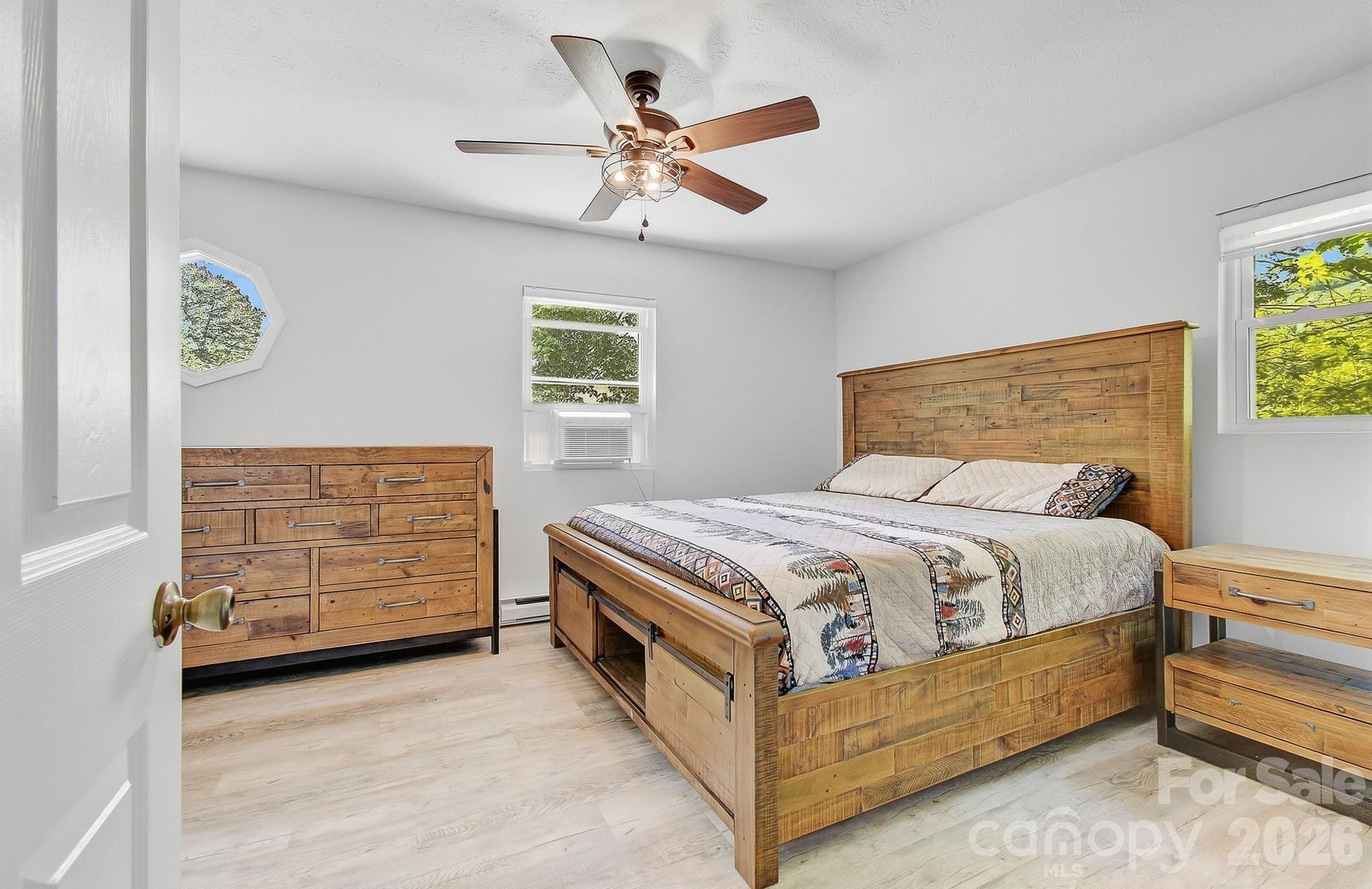 2131 Coleman Mountain Road Waynesville, NC 28785 - Photo 15 of 40 a bedroom with a bed and a ceiling fan