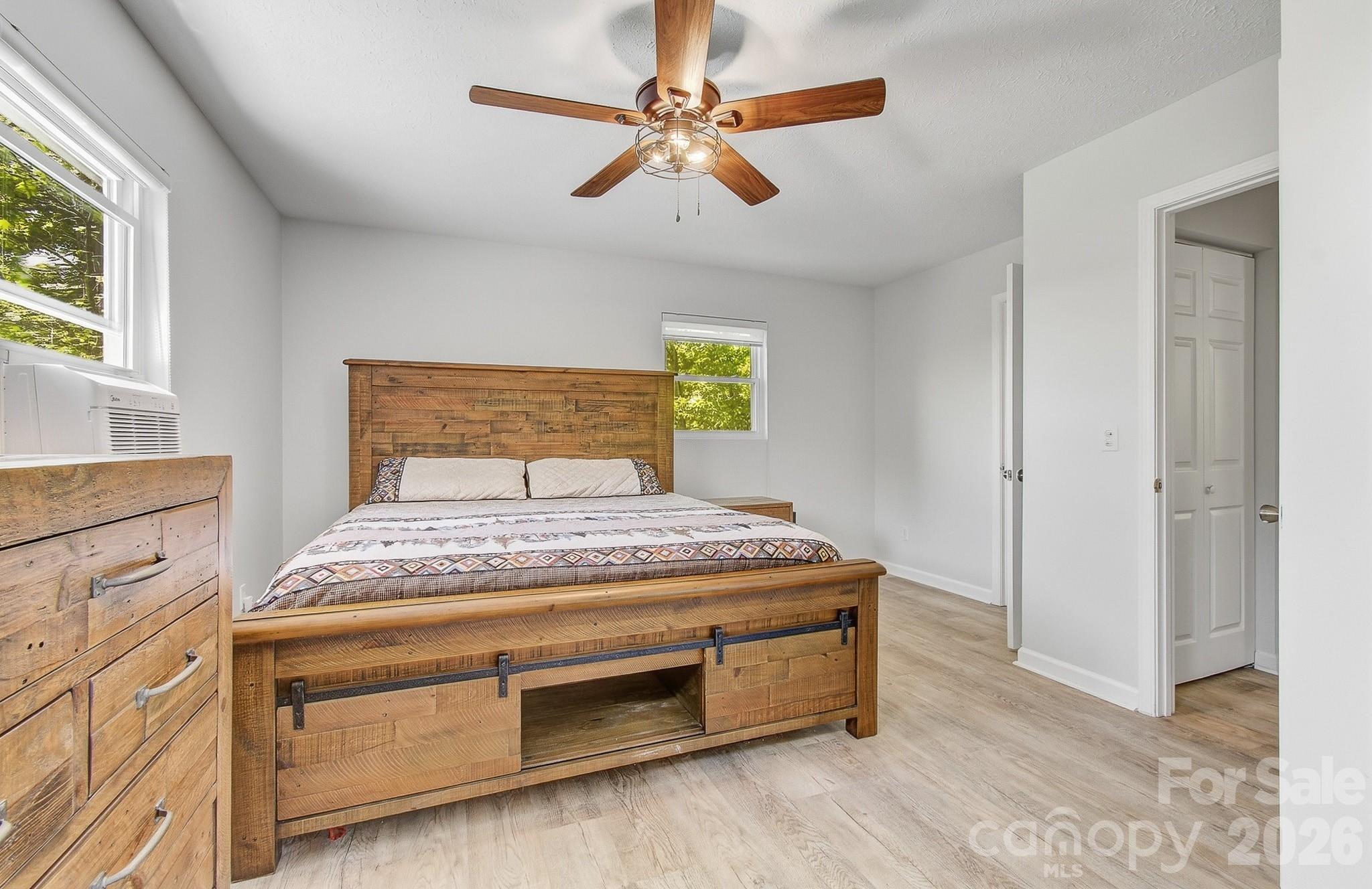 2131 Coleman Mountain Road Waynesville, NC 28785 - Photo 16 of 40 a bedroom with a bed and a chandelier