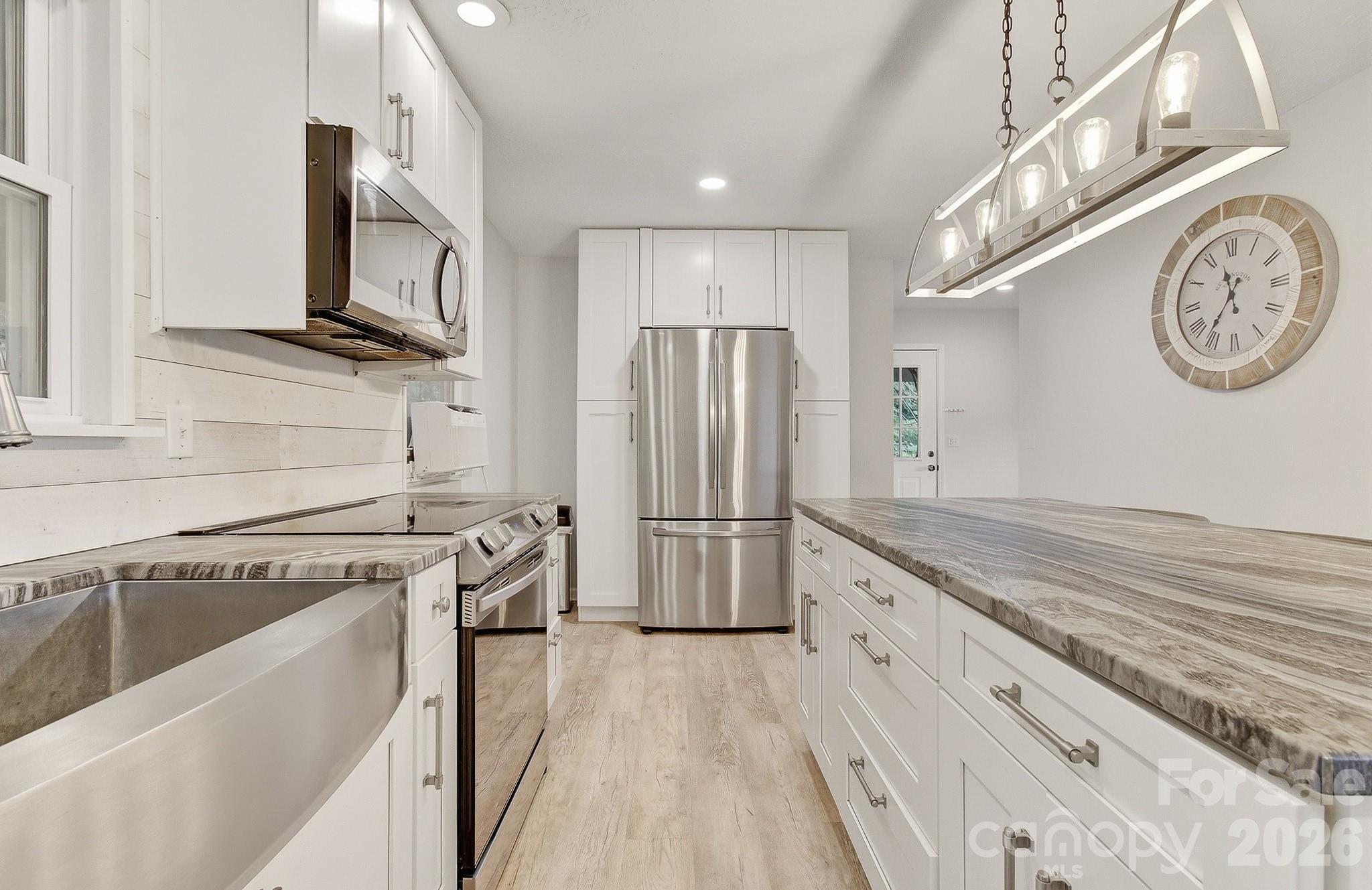 2131 Coleman Mountain Road Waynesville, NC 28785 - Photo 6 of 40 a kitchen with stainless steel appliances granite countertop a refrigerator and a stove