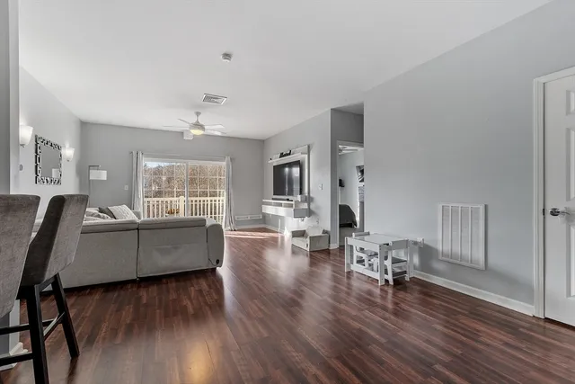 a living room with furniture and a wooden floor