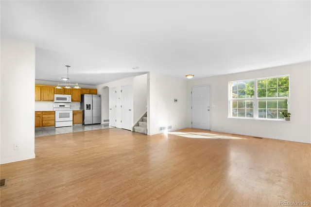 a view of empty room with wooden floor and windows