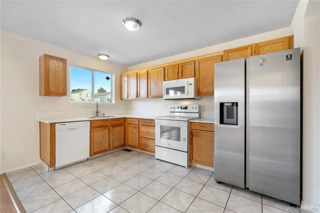 a kitchen with white cabinets stainless steel appliances and a window