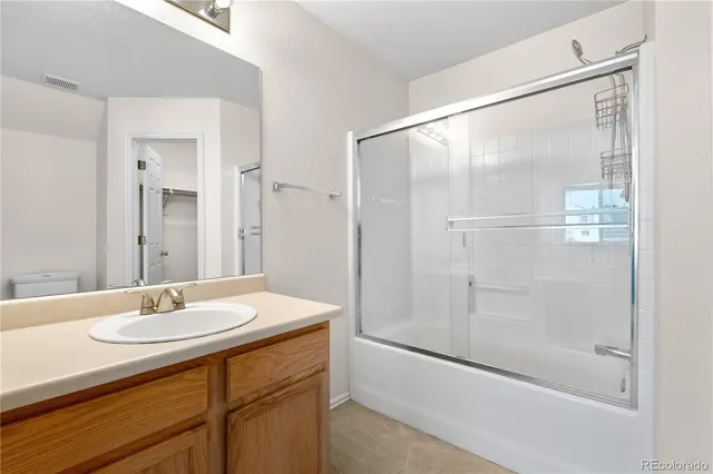 a bathroom with a shower sink and mirror