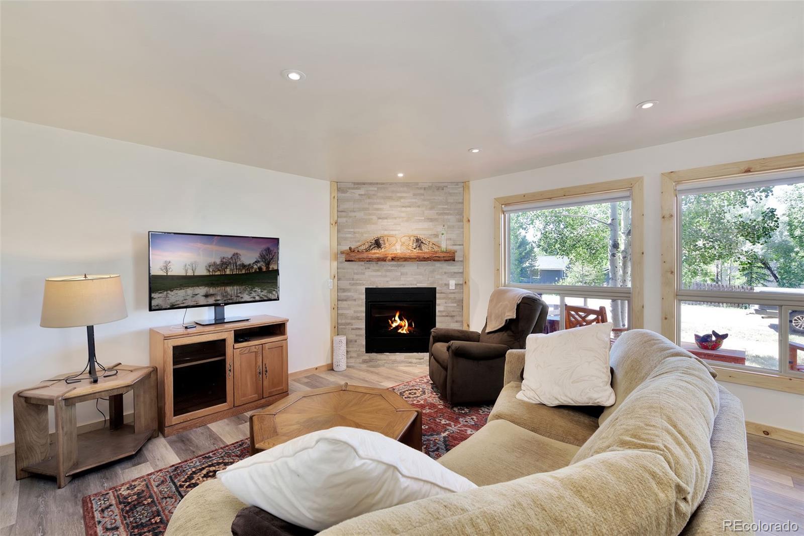 a living room with furniture a flat screen tv and a fireplace