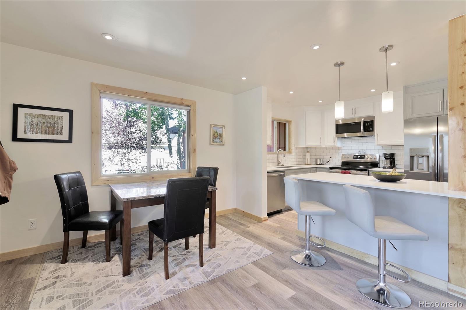 27320 Moonlight Way Steamboat Springs, CO 80487 - Photo 6 of 37 a kitchen with a dining table chairs and white cabinets