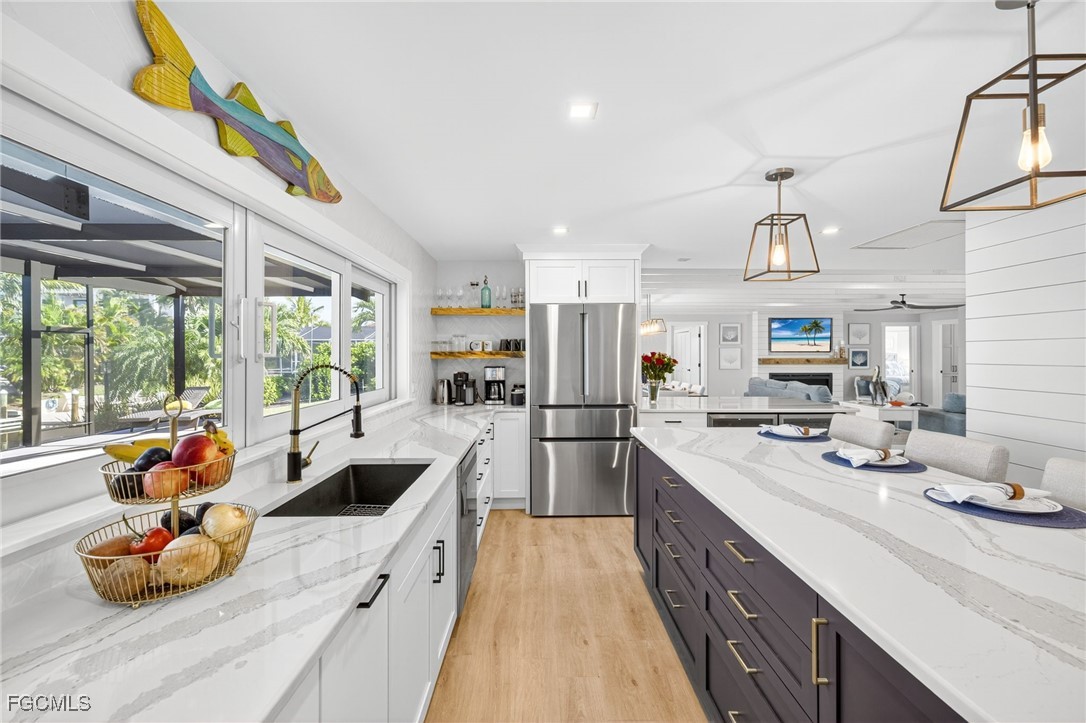 941 Pecten Court Sanibel, FL 33957 - Photo 23 of 44 a kitchen with stainless steel appliances a sink a stove and a refrigerator