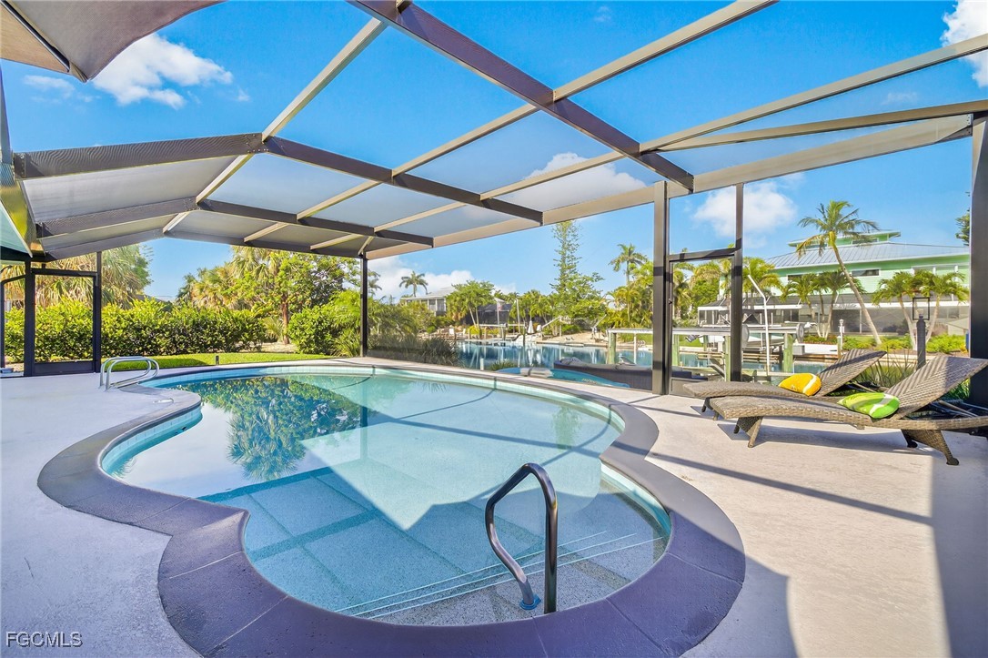 941 Pecten Court Sanibel, FL 33957 - Photo 4 of 44 a view of a swimming pool with a chairs in patio