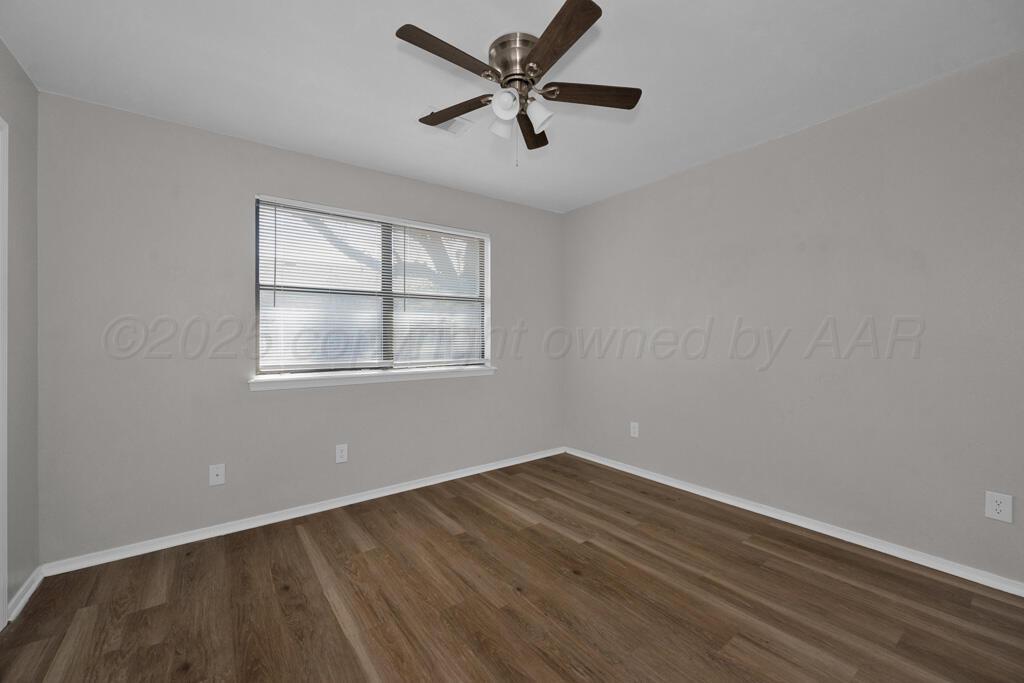 4200 South Austin Street, Unit B Amarillo, TX 79110 - Photo 11 of 13 wooden floor in an empty room with a window