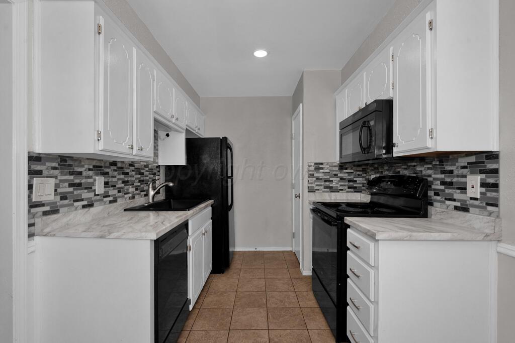 4200 South Austin Street, Unit B Amarillo, TX 79110 - Photo 6 of 13 a kitchen with a sink stove and white cabinets