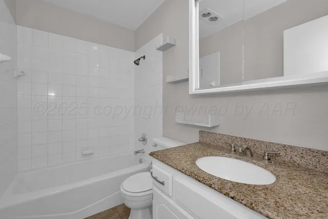 a bathroom with a granite countertop sink toilet mirror and shower