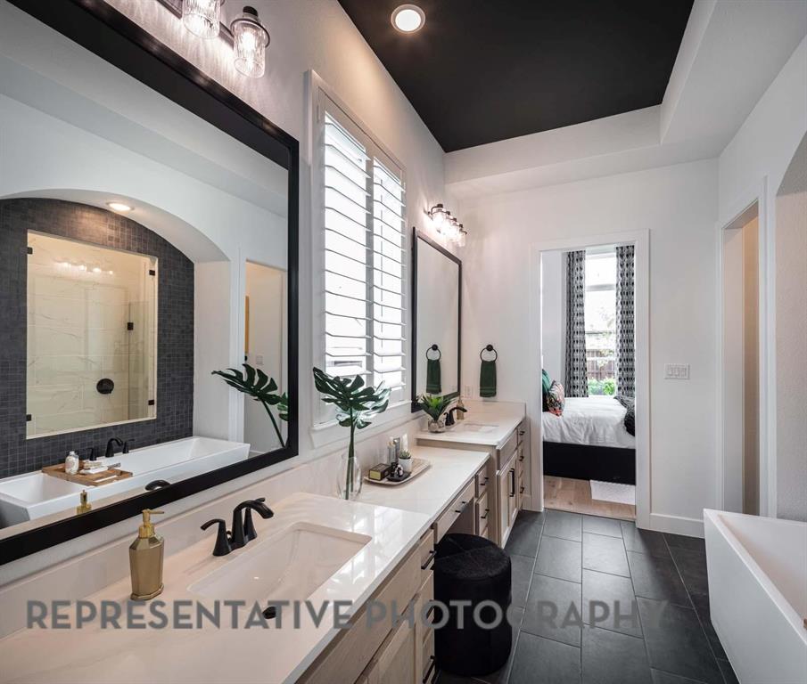 930 Heatherbrook Drive Prosper, TX 75078 - Photo 16 of 37 a spacious bathroom with a double vanity sink and a mirror