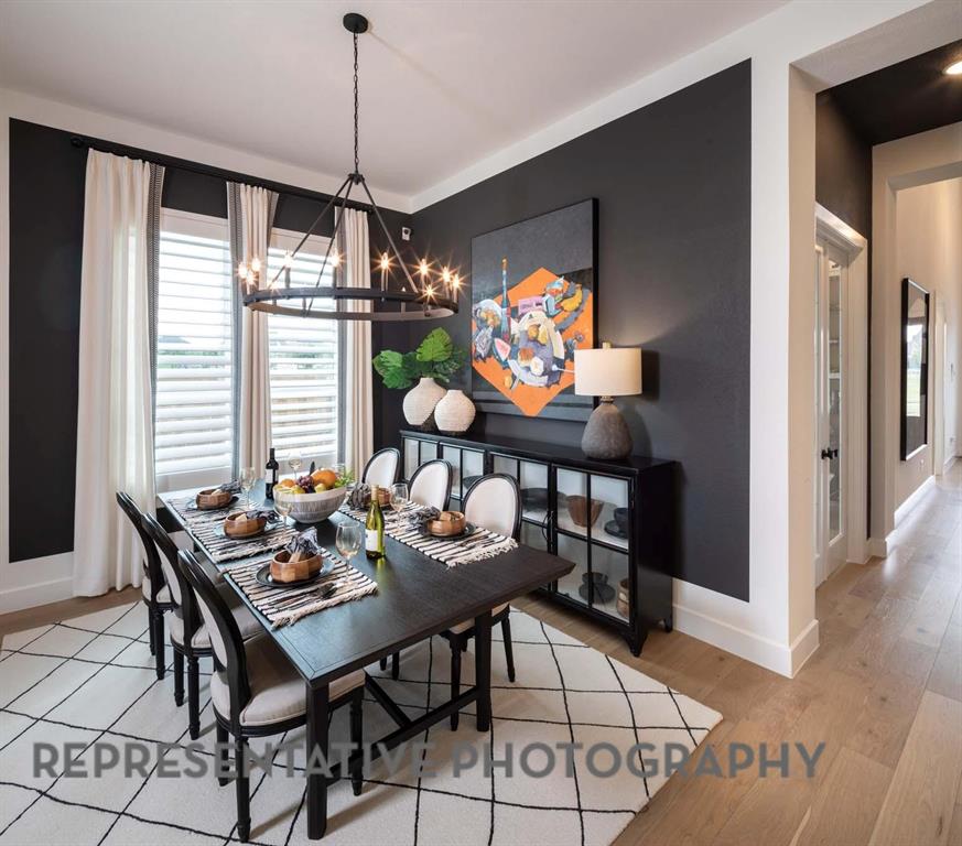 930 Heatherbrook Drive Prosper, TX 75078 - Photo 27 of 37 a dining room with furniture a flat screen tv and a chandelier