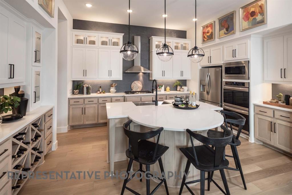930 Heatherbrook Drive Prosper, TX 75078 - Photo 7 of 37 a kitchen with stainless steel appliances kitchen island granite countertop a sink and cabinets