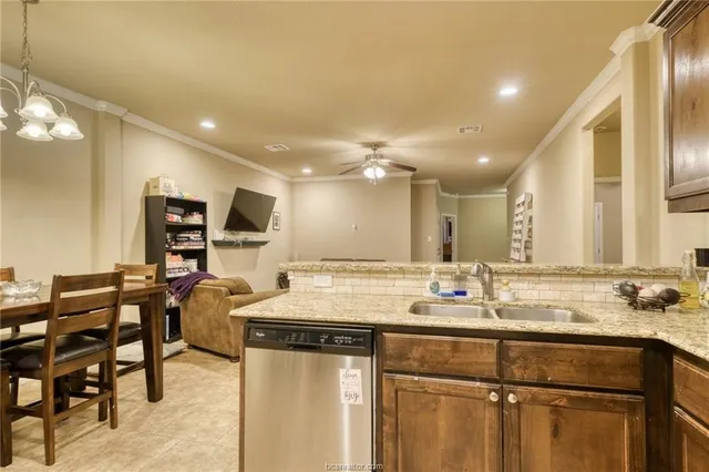 a kitchen with stainless steel appliances kitchen island granite countertop a sink and cabinets