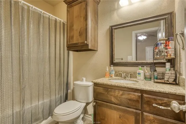 a bathroom with a toilet a sink and mirror