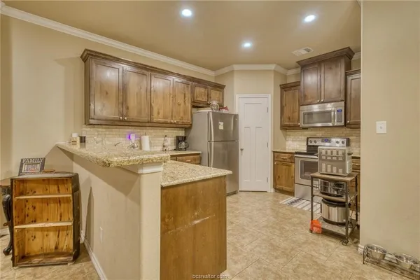 a kitchen with kitchen island granite countertop cabinets and refrigerator
