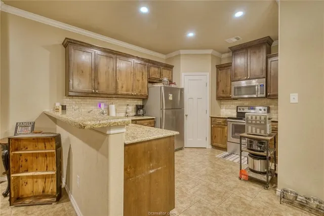 a kitchen with kitchen island granite countertop cabinets and refrigerator