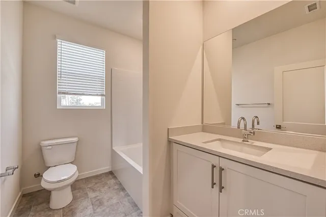 a bathroom with a toilet a sink a mirror and a window