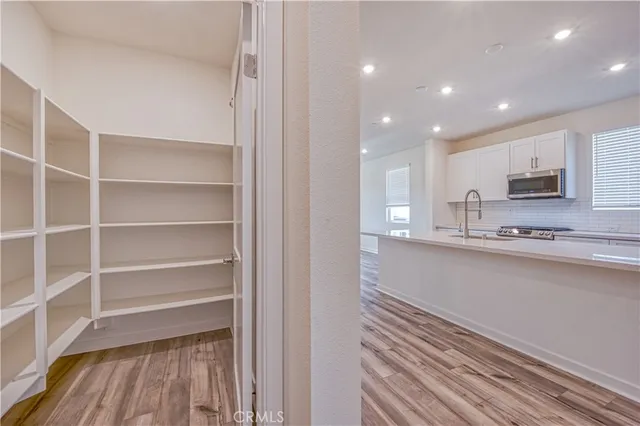 a view of kitchen with wooden floor and electronic appliances