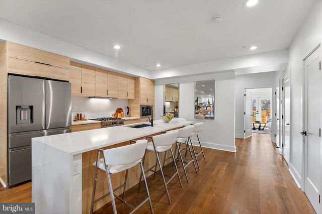 a kitchen with stainless steel appliances a table and chairs in it