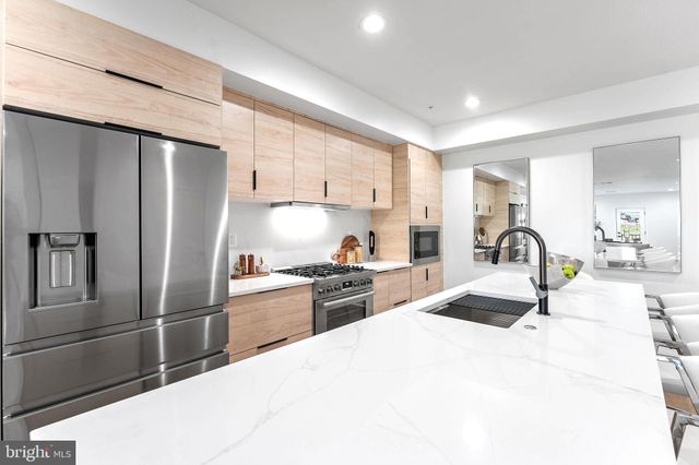 a kitchen with granite countertop a refrigerator and a sink