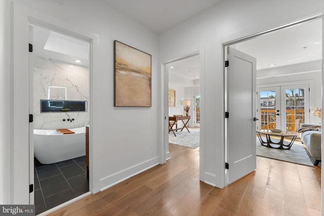 a view of a hallway with wooden floor and a living room
