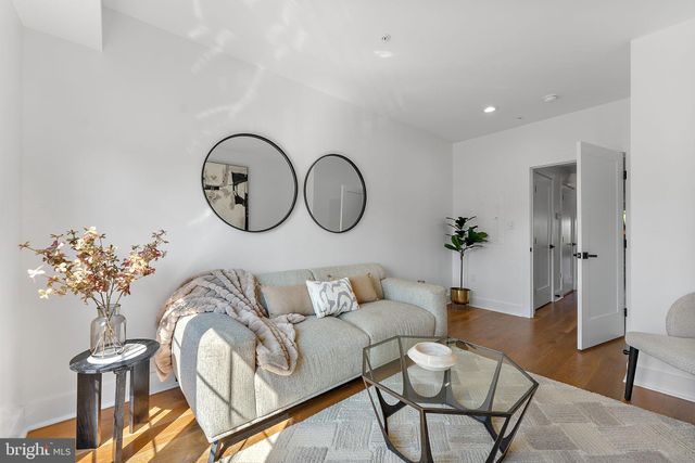 a living room with furniture a table and a potted plant