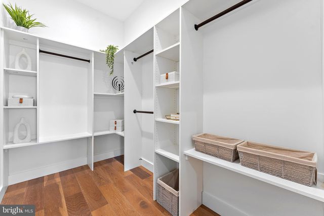 a view of cabinets and entryway with wooden floor