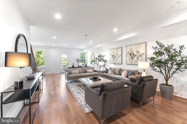 a living room with furniture a window and a lamp