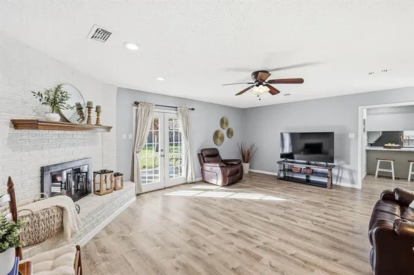 a living room with furniture and a flat screen tv with kitchen view