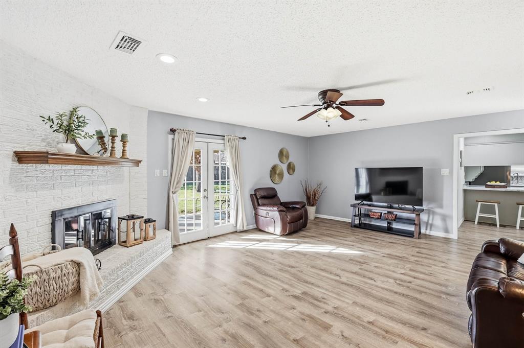 a living room with furniture and a flat screen tv with kitchen view