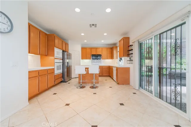 a kitchen with stainless steel appliances a refrigerator and a stove top oven