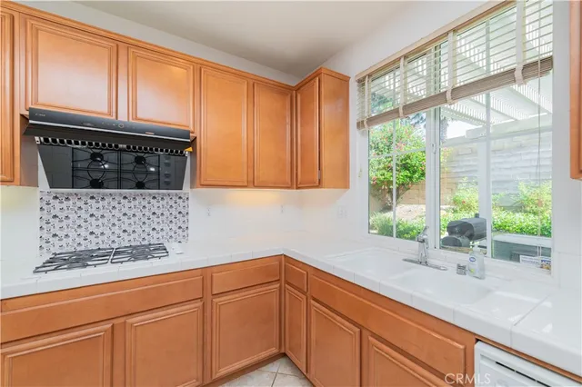 a kitchen with stainless steel appliances wooden cabinets and a window