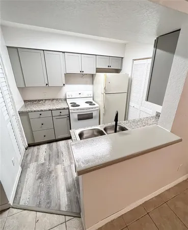 a kitchen with white cabinets and sink