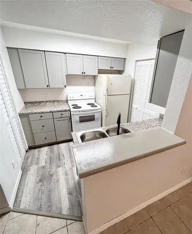 a kitchen with white cabinets and sink