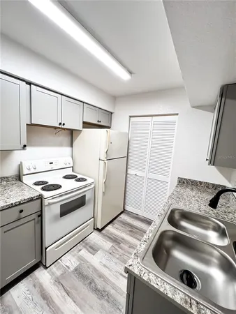 a kitchen with granite countertop a sink and a stove top oven