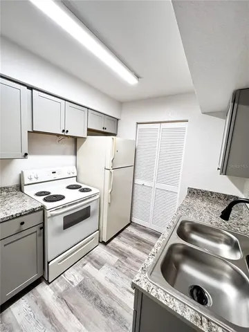 a kitchen with granite countertop a sink and a stove top oven