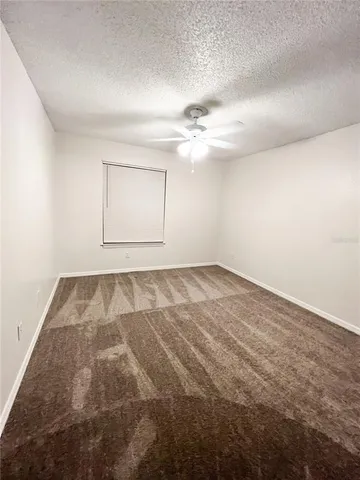 an empty room with a chandeliers fan
