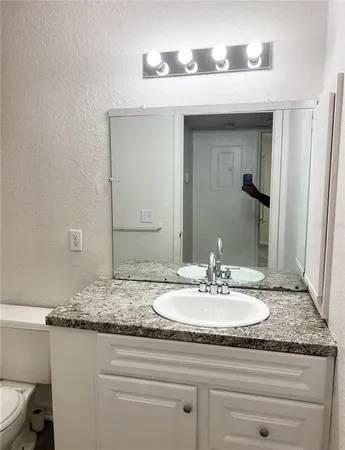 a bathroom with a granite countertop sink and a mirror