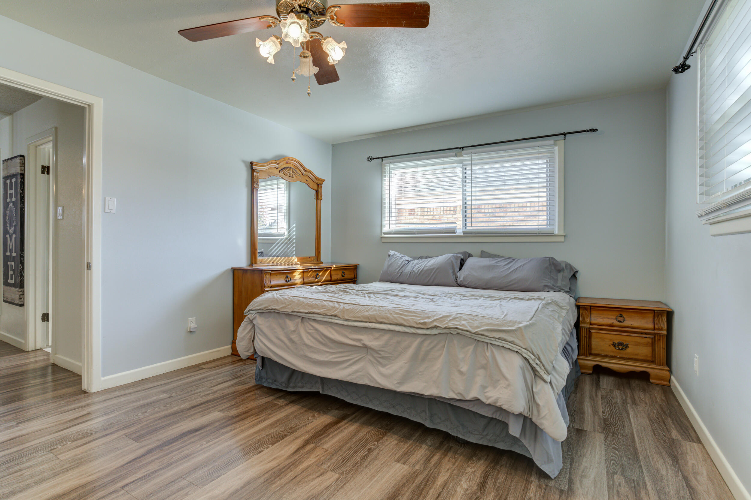 2120 53rd Street Lubbock, TX 79412 - Photo 21 of 32 a bedroom with a bed and a chandelier