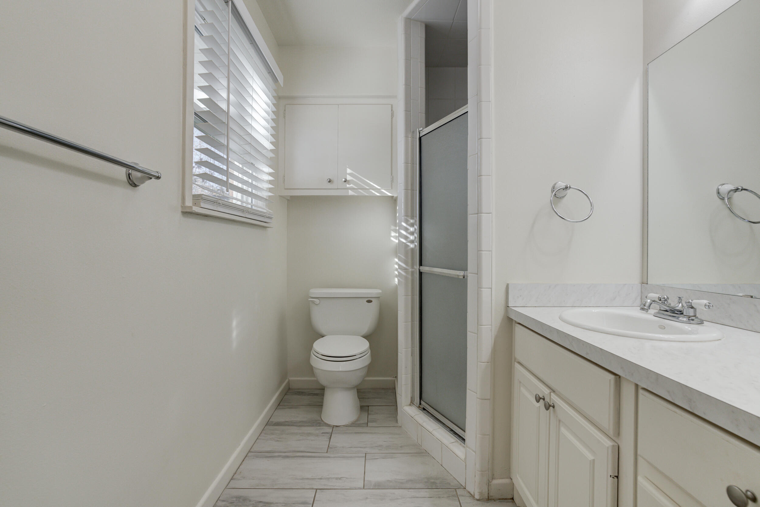 2120 53rd Street Lubbock, TX 79412 - Photo 22 of 32 a bathroom with a granite countertop toilet a sink and a mirror