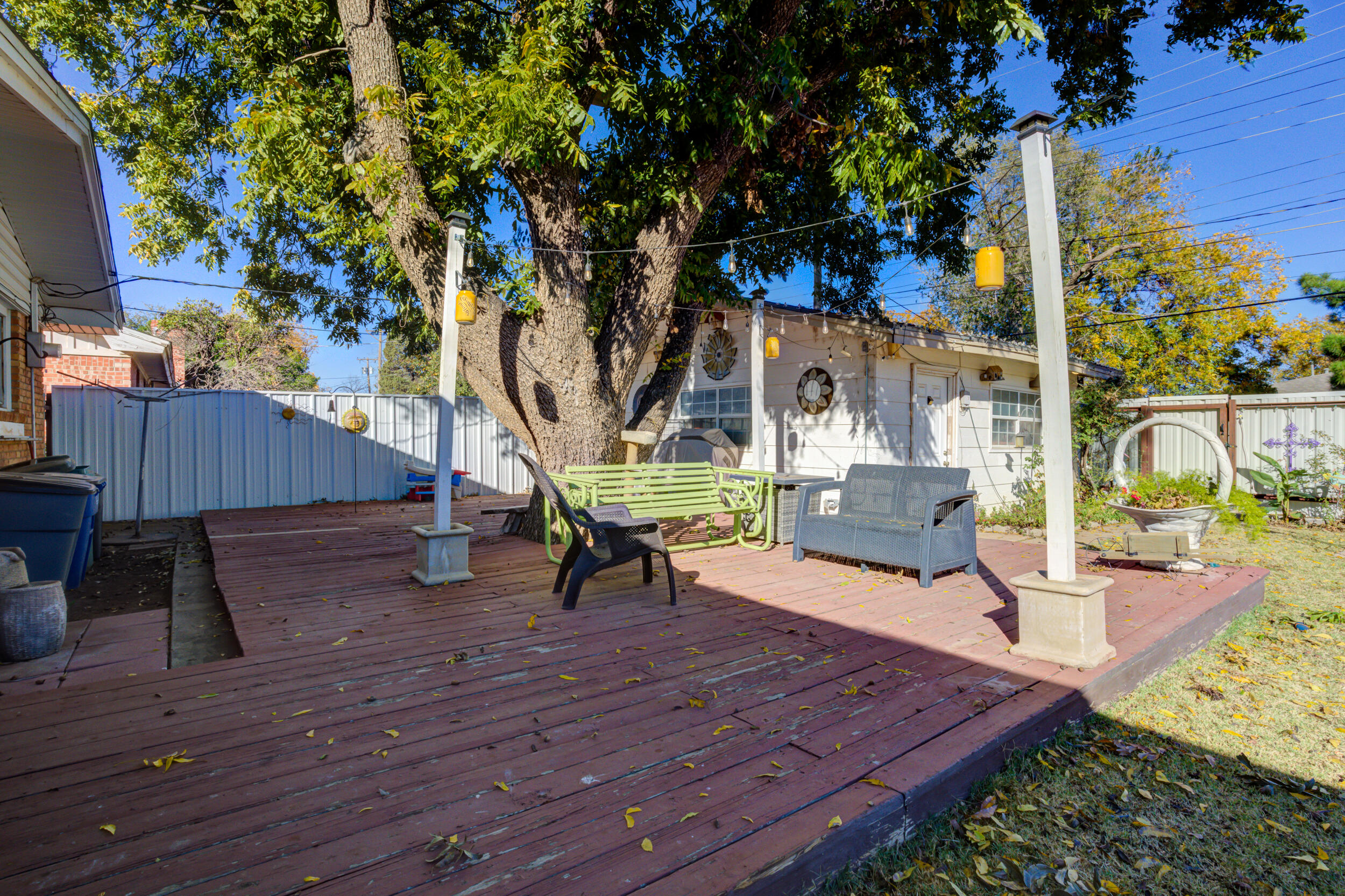 2120 53rd Street Lubbock, TX 79412 - Photo 26 of 32 a view of a deck with table and chairs with wooden floor and fence
