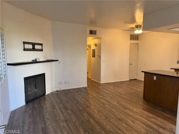 a view of empty room with wooden floor and fireplace