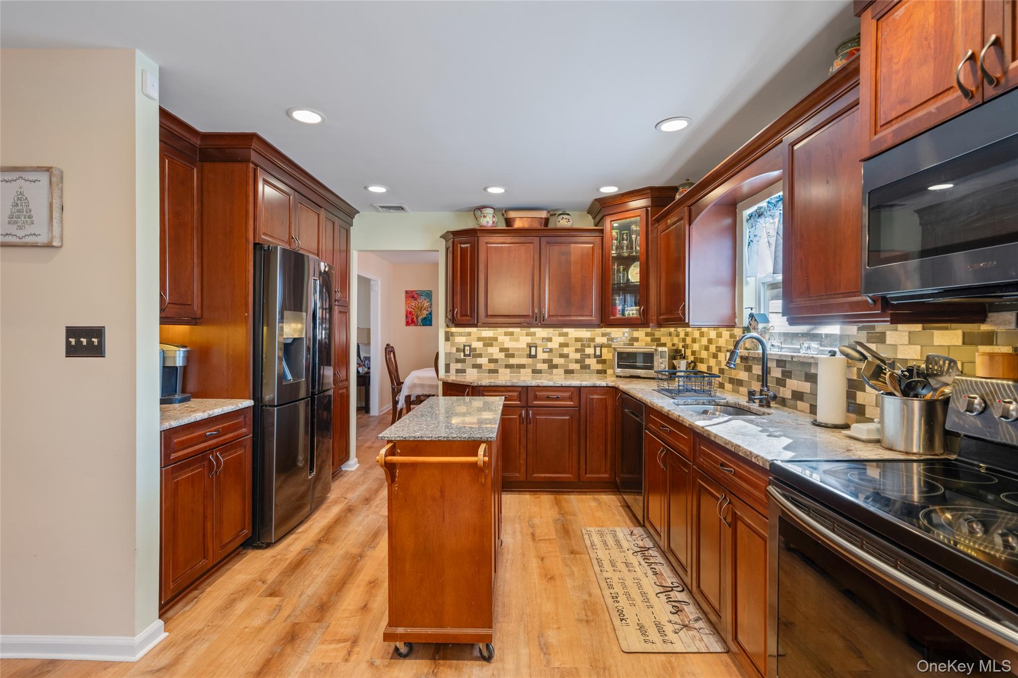 194 Miller Place Road Miller Place, NY 11764 - Photo 11 of 50 a kitchen with stainless steel appliances granite countertop a refrigerator a stove top oven and sink